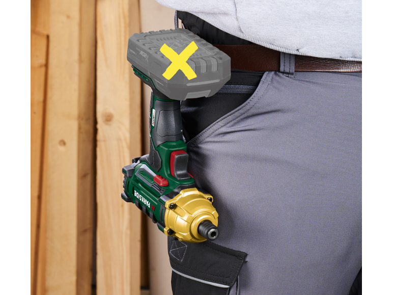 Persona che indossa pantaloni da lavoro con avvitatore a impulsi e batteria attaccati alla cintura.