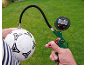 Manometro digitale per pneumatici con tubo che gonfia un pallone da calcio su un prato.