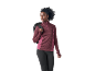 Donna con top a maniche lunghe bordeaux con mezza zip e leggings neri, con uno zaino.