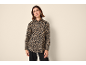 Donna con camicia leopardata e pantaloni neri.
