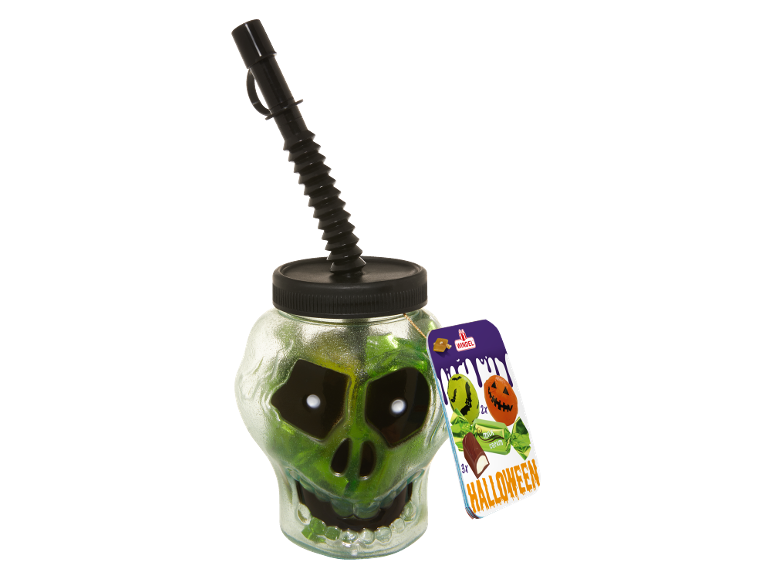 Bicchiere a forma di teschio verde con cannuccia nera e etichetta di dolcetti di Halloween.