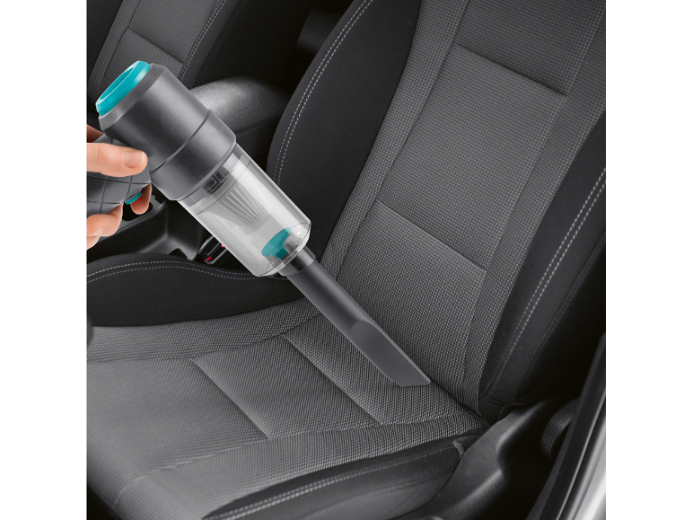 Aspirapolvere portatile senza fili che pulisce l'interno di un'auto.