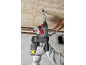 Trapano a percussione a batteria che fora un soffitto di cemento.
