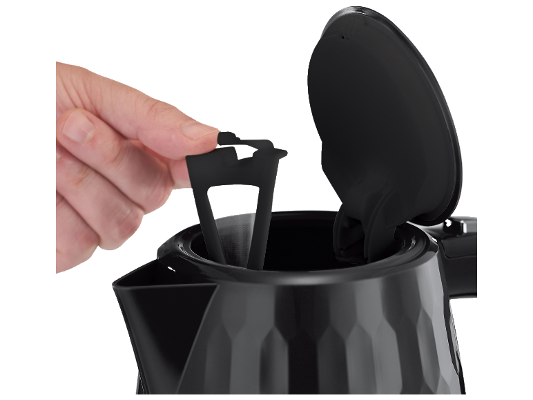 Mano inserisce un filtro dell'acqua nero in un bollitore nero sfaccettato.