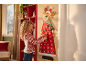 Bambina con maglione natalizio appende un ornamento a un calendario dell'avvento in feltro a forma di renna.