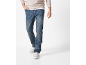 Uomo con felpa beige, maglietta bianca e jeans blu con scarpe da ginnastica bianche.