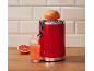 Spremiagrumi rosso con succo di pompelmo appena spremuto in un bicchiere.