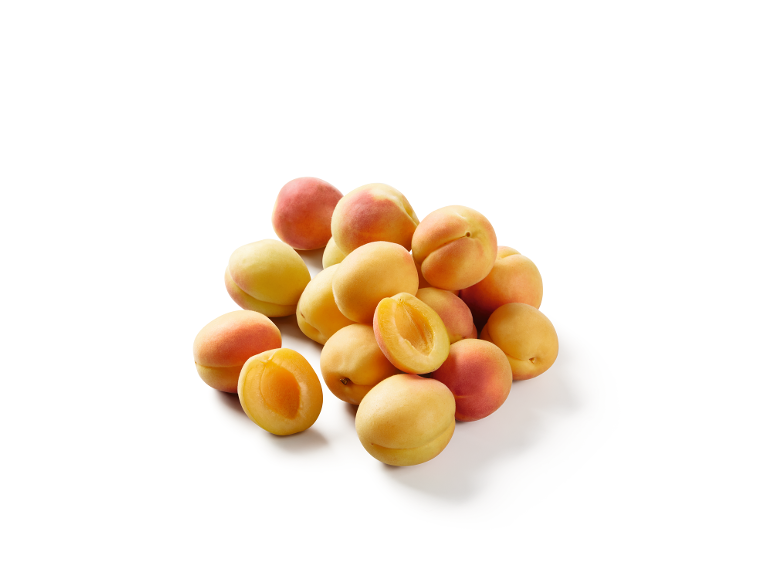Un mucchio di albicocche fresche, alcune intere e altre tagliate a metà, su sfondo bianco.