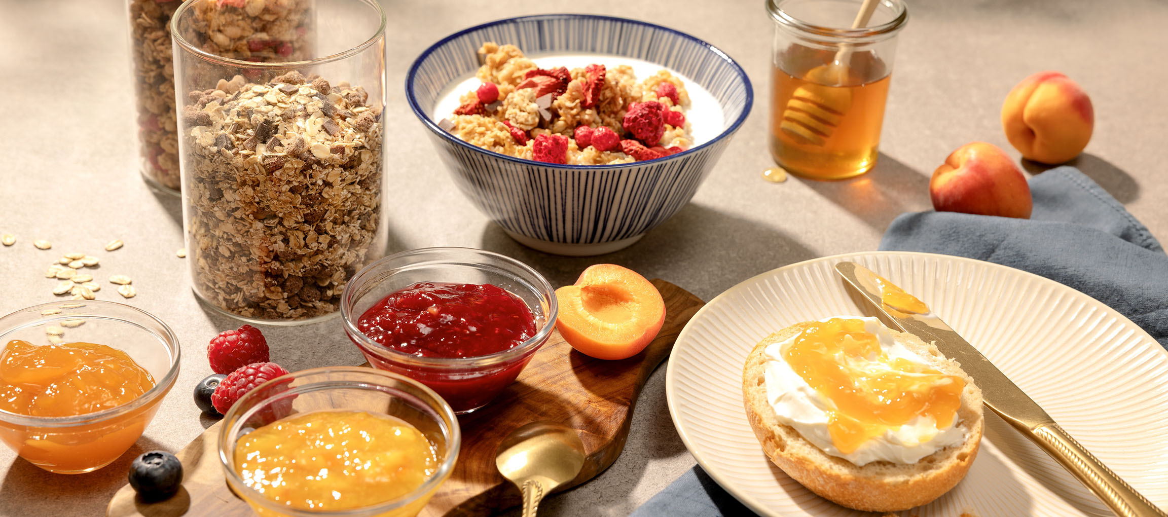 Colazione con muesli, marmellata, miele e pane con crema di formaggio e marmellata.