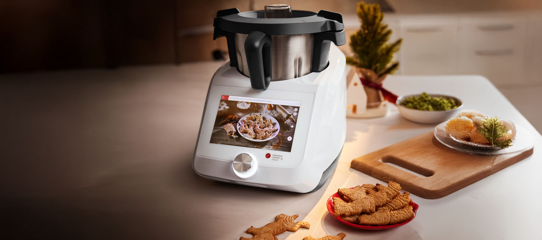 Robot da cucina Monsieur Cuisine Smart con biscotti natalizi e decorazioni festive.