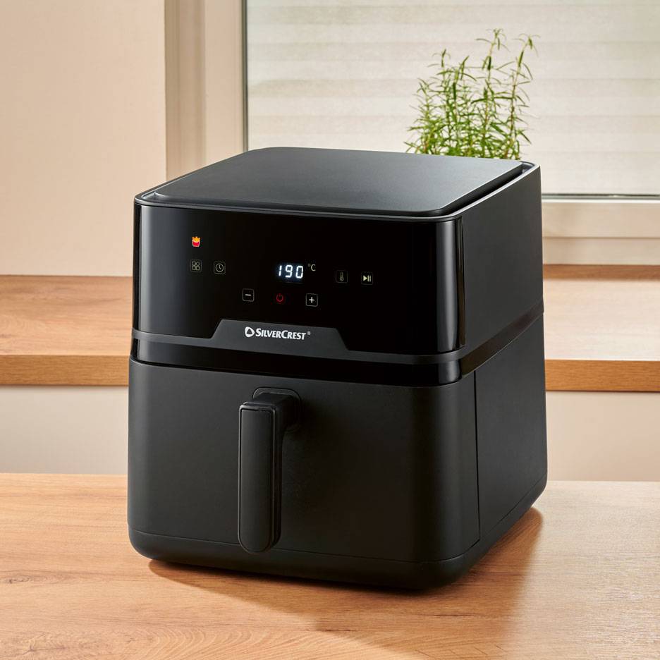 Friggitrice ad aria digitale nera su un tavolo di legno, con 190 °C sul display.