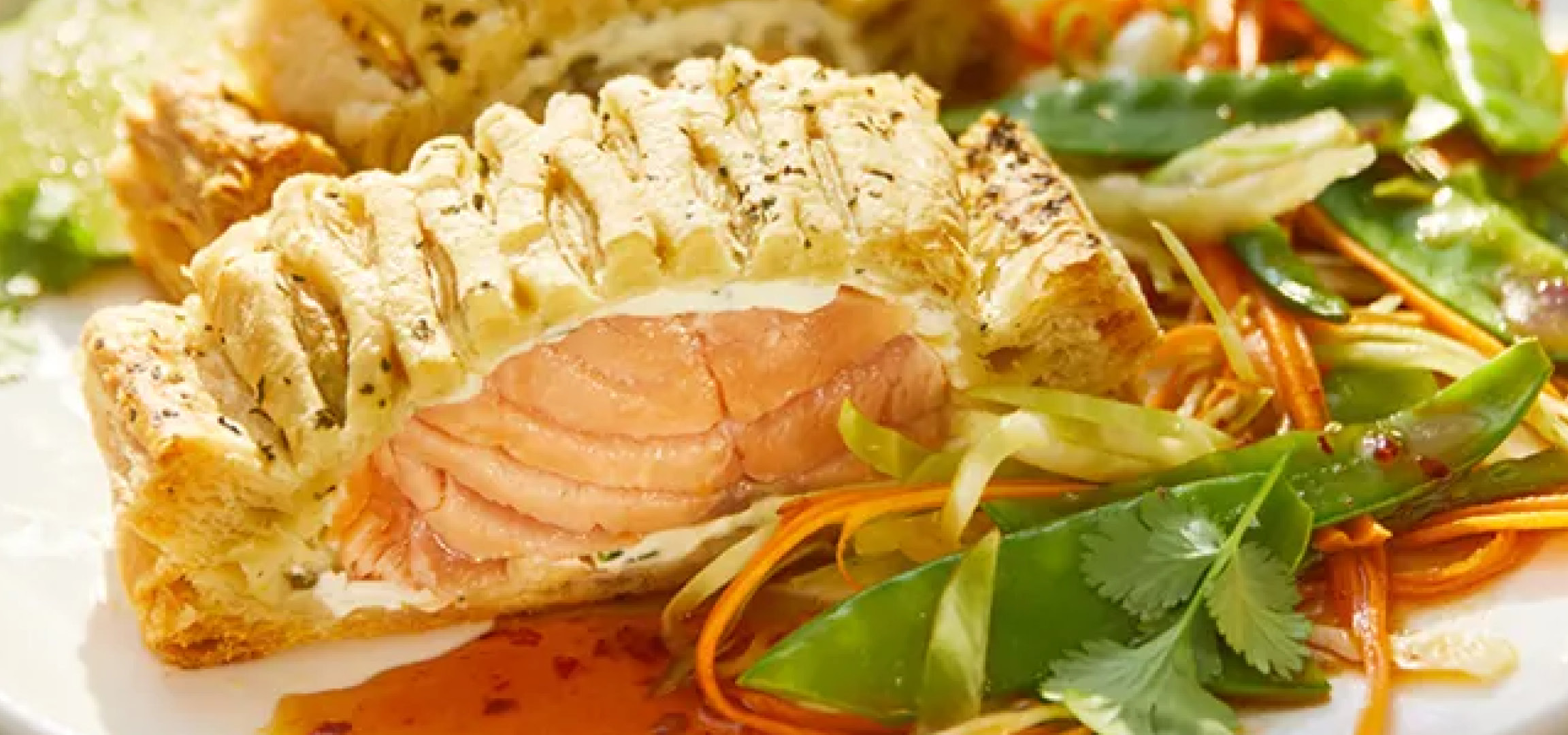 Salmone in crosta con verdure saltate e salsa agrodolce su un piatto bianco.