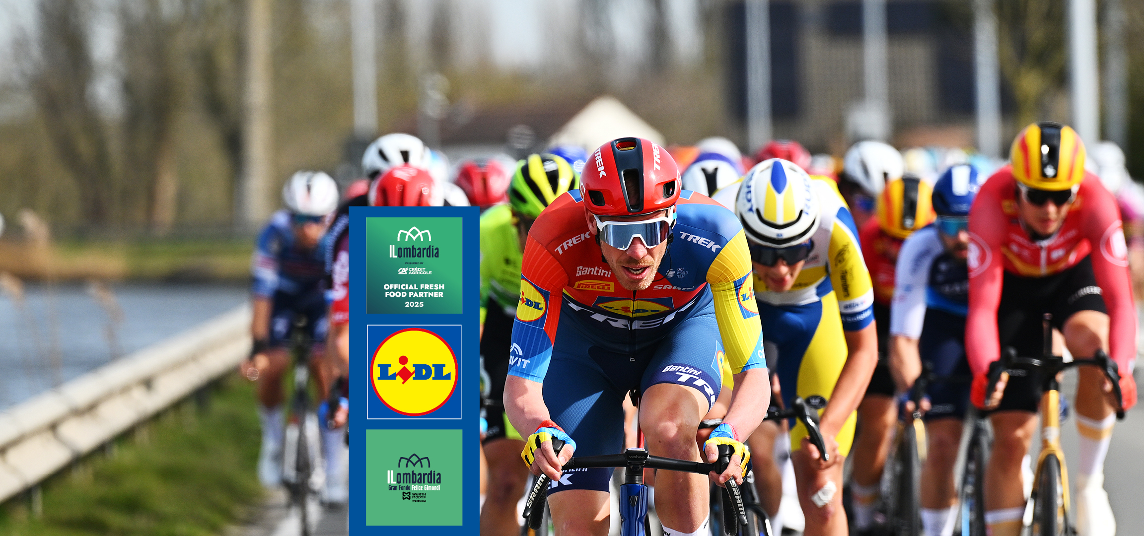 Ciclisti in gara con maglie e caschi colorati, con loghi Lidl e Il Lombardia.