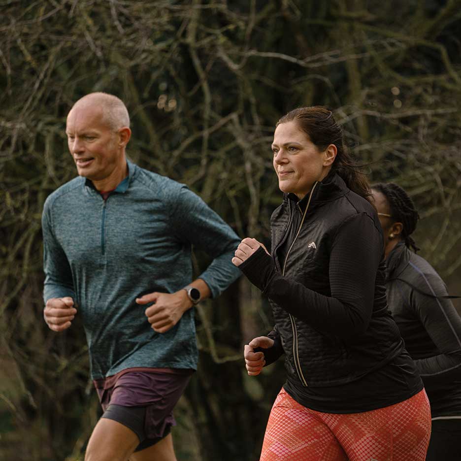 Due corridori adulti in abbigliamento sportivo fanno jogging all'aperto.