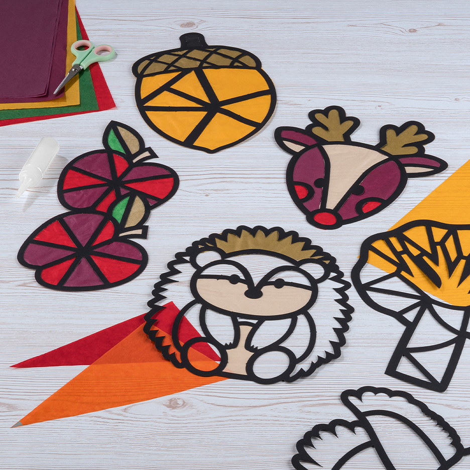 Decorazioni autunnali in carta colorata, tra cui una ghianda, un riccio e un cervo.