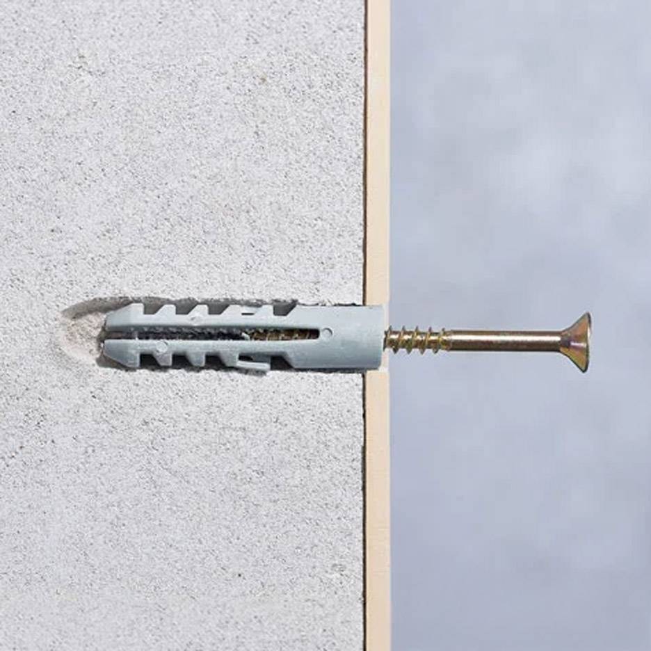 Vite da trapano e tassello a muro in una parete di cemento