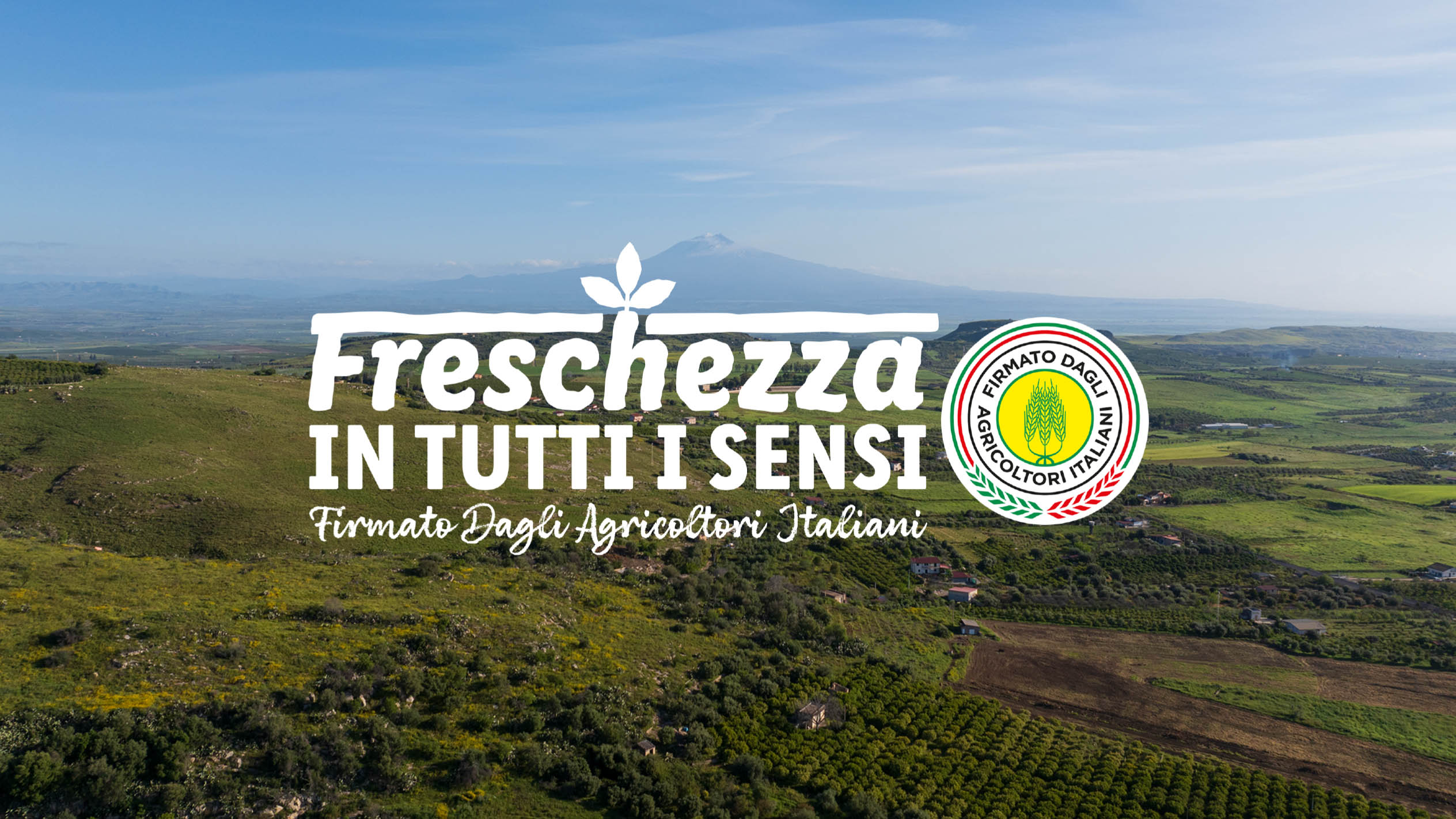 Paesaggio agricolo italiano con il testo 'Freschezza in tutti i sensi' e il logo 'Firmato Dagli Agricoltori Italiani'.