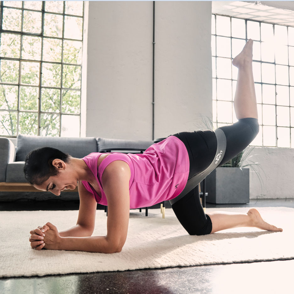 Donna che fa esercizi per le gambe con fascia di resistenza Senfit.