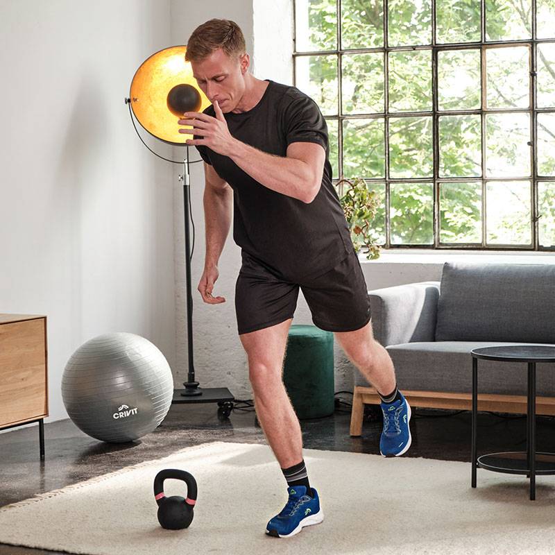 Un uomo si allena con palla medica, kettlebell e palla da ginnastica Crivit