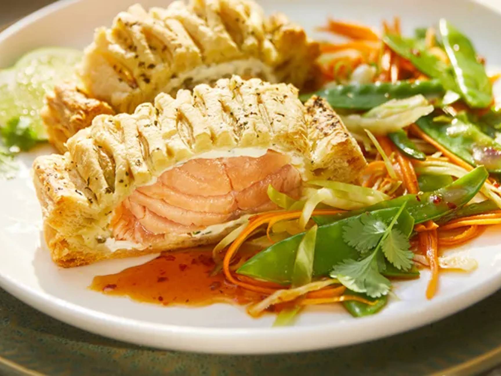 Salmone in crosta con verdure miste e salsa agrodolce su un piatto bianco.