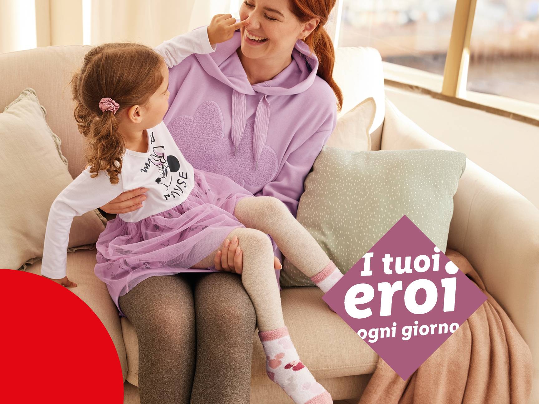 Una donna e una bambina sedute su un divano, la bambina indossa una maglietta di Minnie.