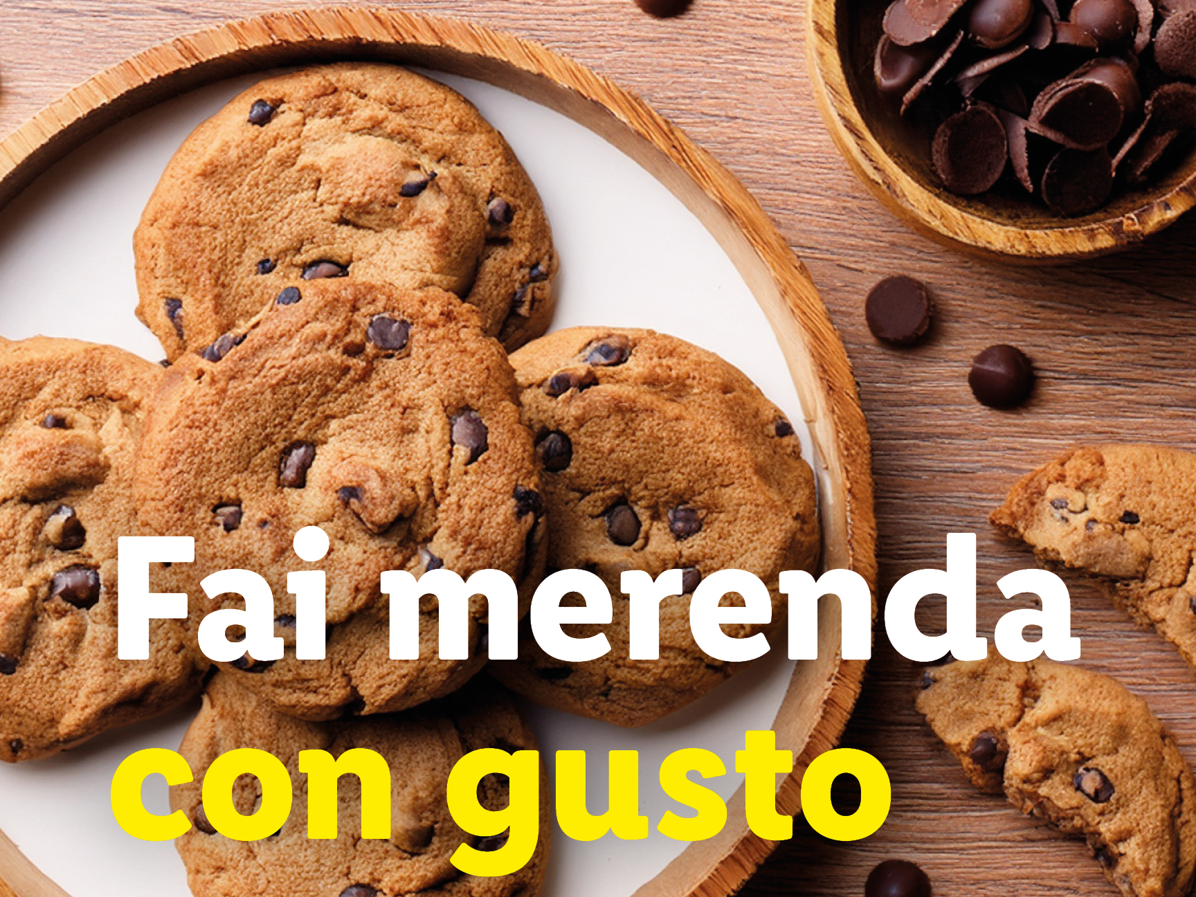 Biscotti con gocce di cioccolato su un piatto di legno, con scaglie di cioccolato.