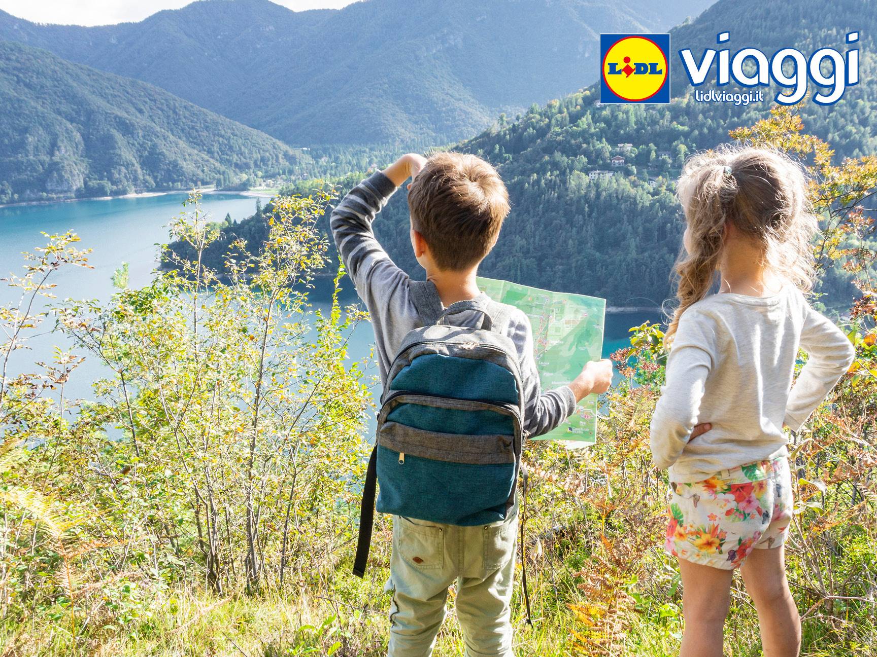 Bambini con zaino e mappa che guardano un lago di montagna, con logo Lidl Viaggi.