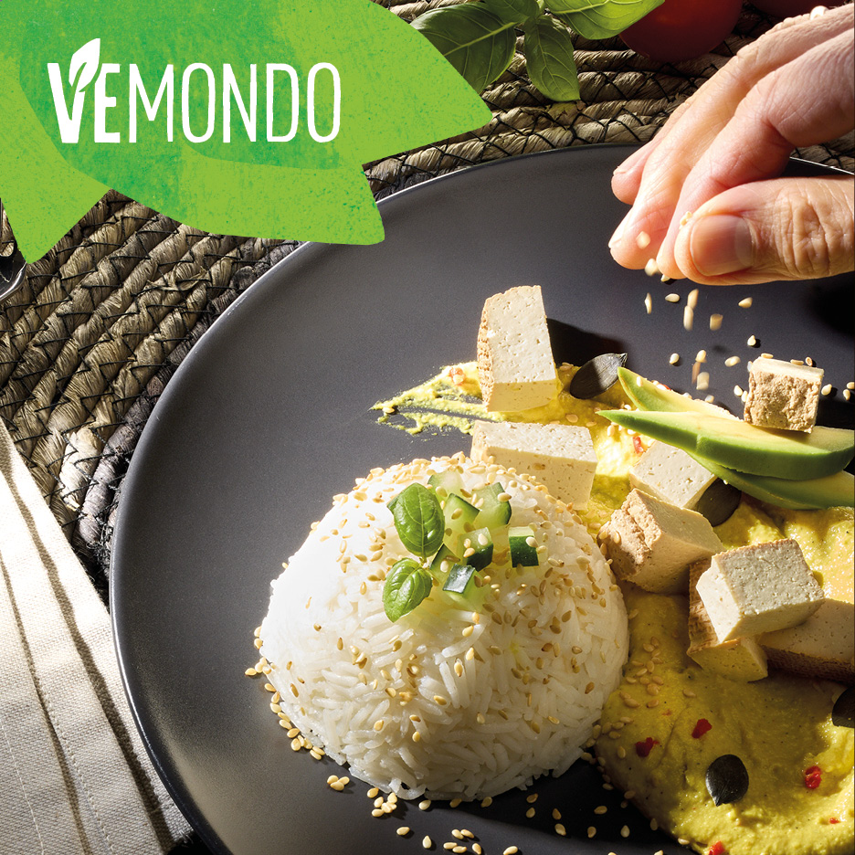 Piatto Vemondo con riso, tofu, avocado e salsa, guarnito con semi di sesamo.