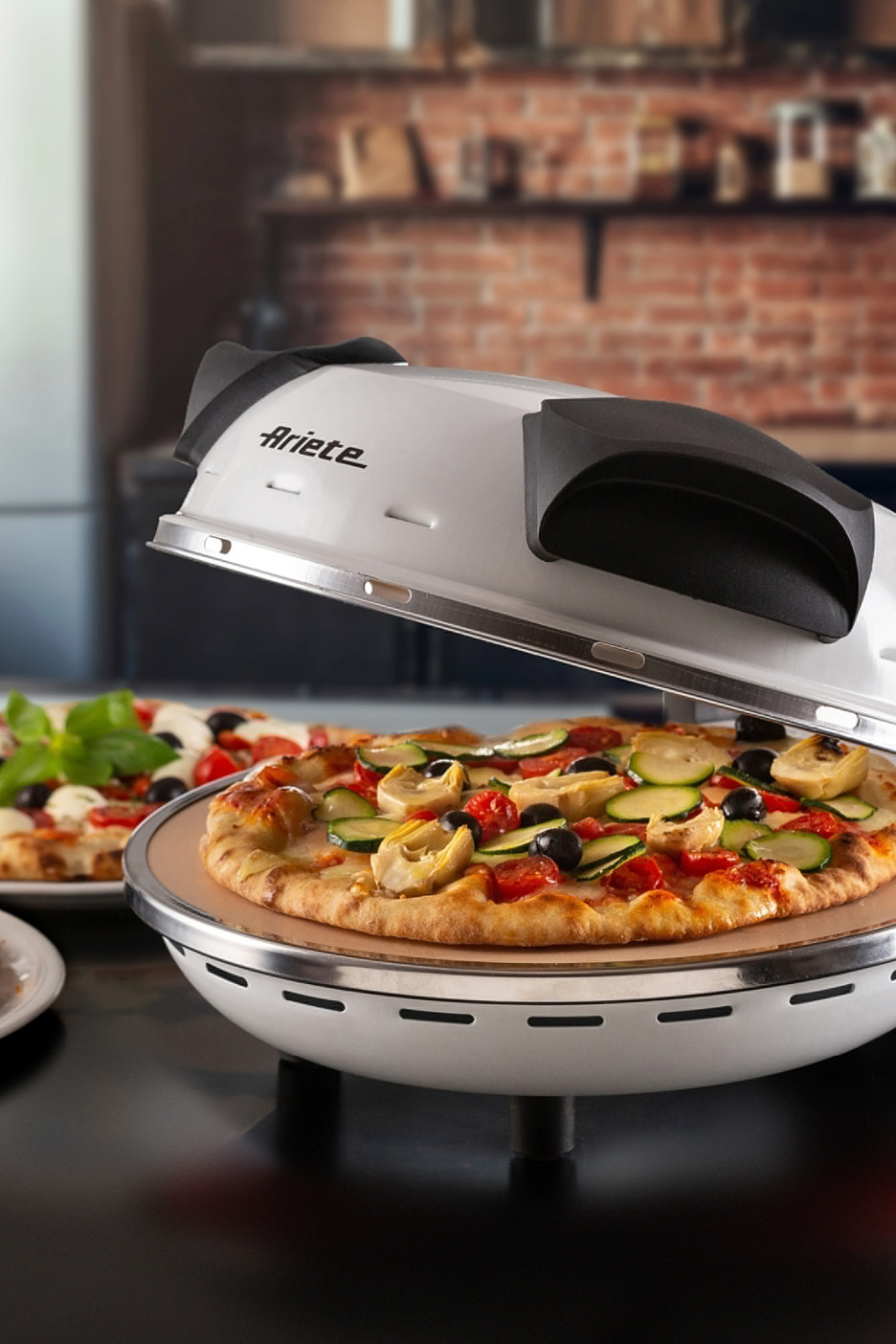 Forno per pizza Ariete con pizza vegetariana e un'altra pizza sullo sfondo.