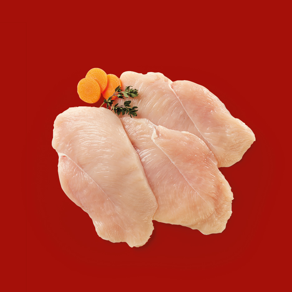 Fettine di petto di pollo crude con carote e timo su sfondo rosso.