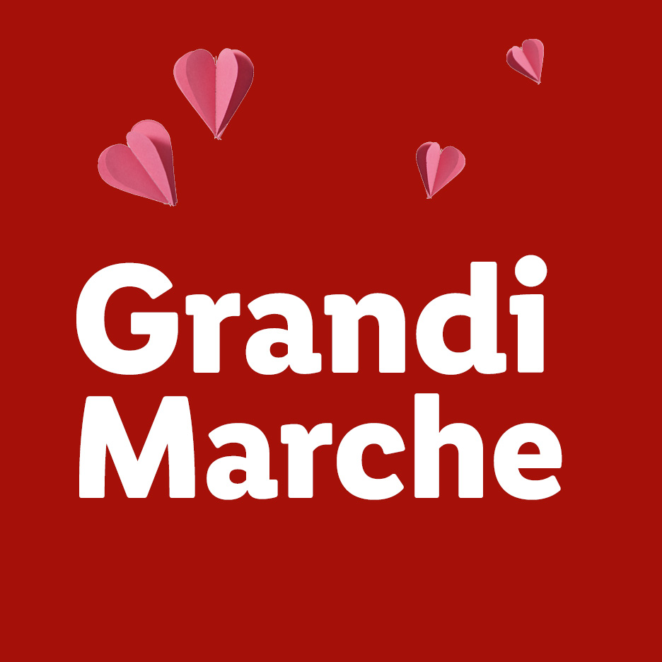 Sfondo rosso con cuori rosa e testo bianco 'Grandi Marche'.