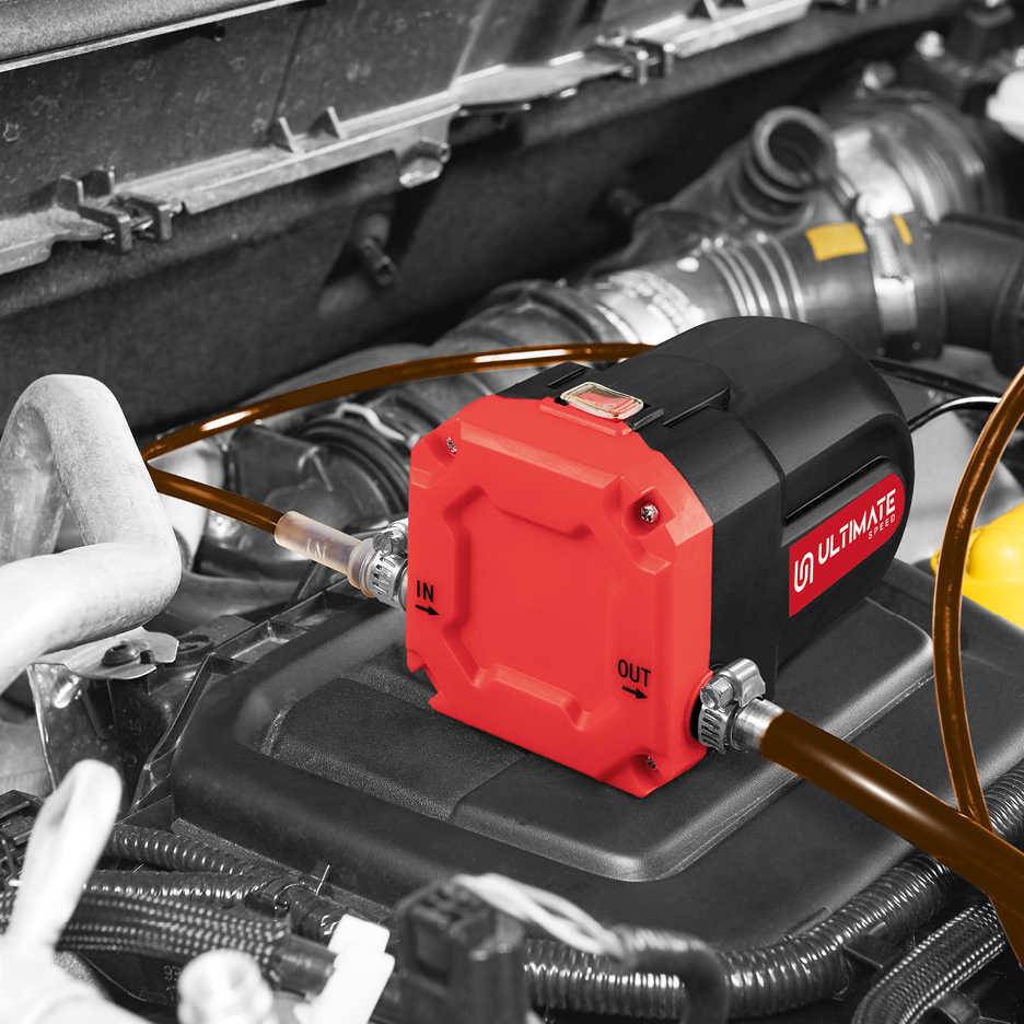 Pompa di estrazione olio rossa e nera con tubi, in un vano motore di un'auto.