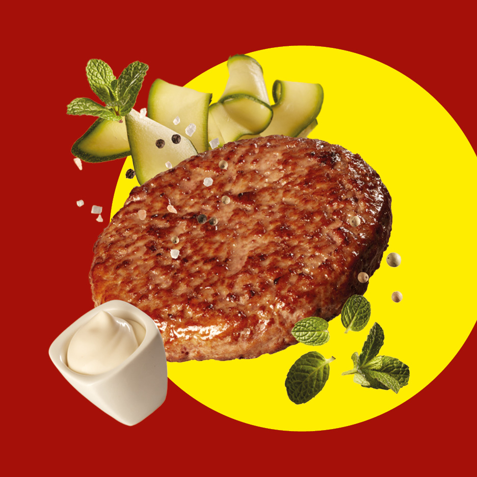 Hamburger di manzo con zucchine, menta e maionese su sfondo rosso e giallo.