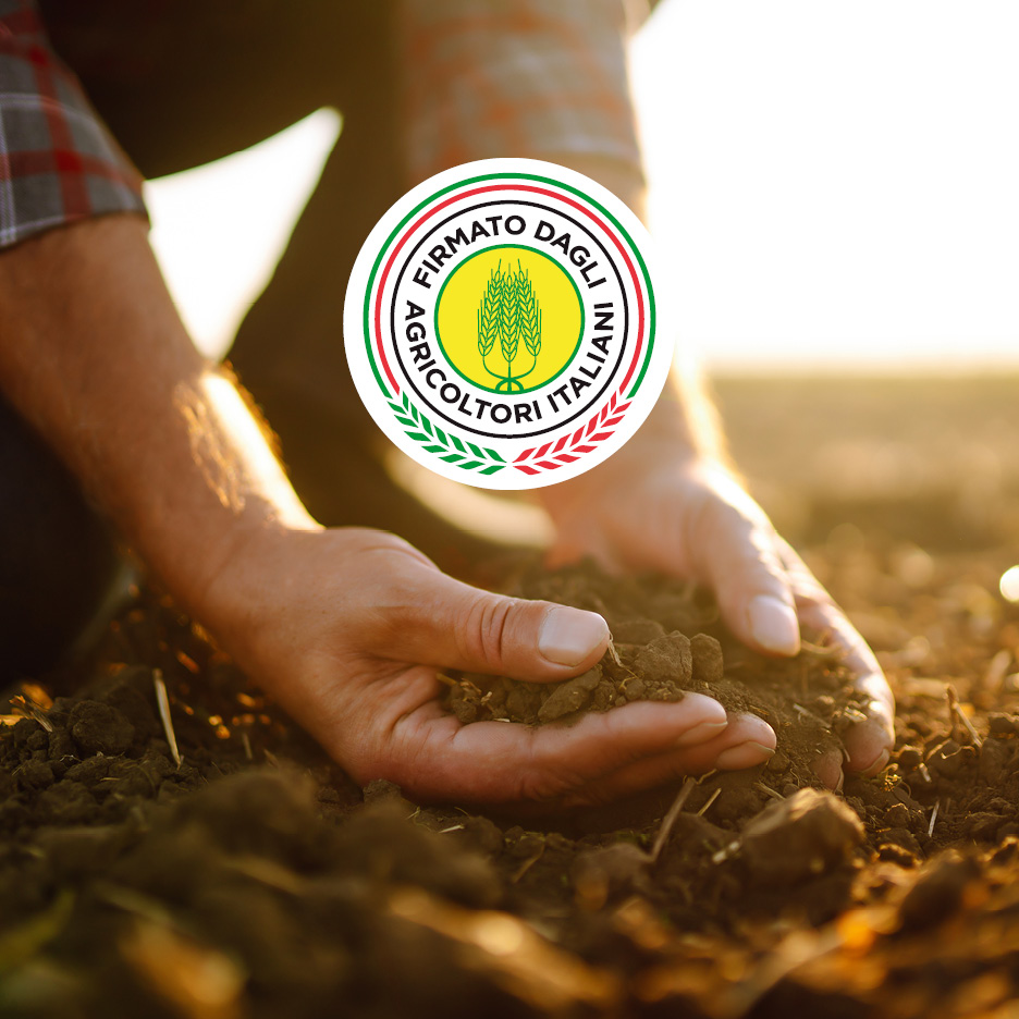 Mani di un agricoltore che tengono la terra, con un logo circolare che recita 'Firmato dagli Agricoltori Italiani'.