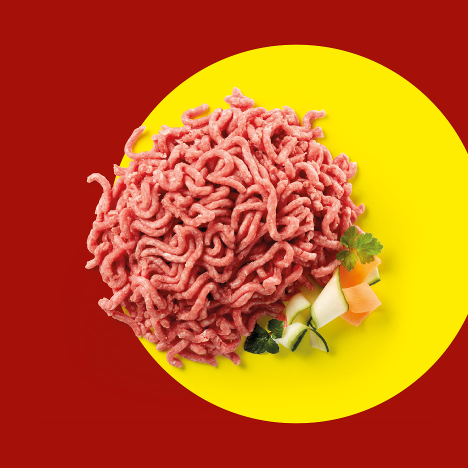 Carne macinata con verdure su sfondo giallo e rosso.