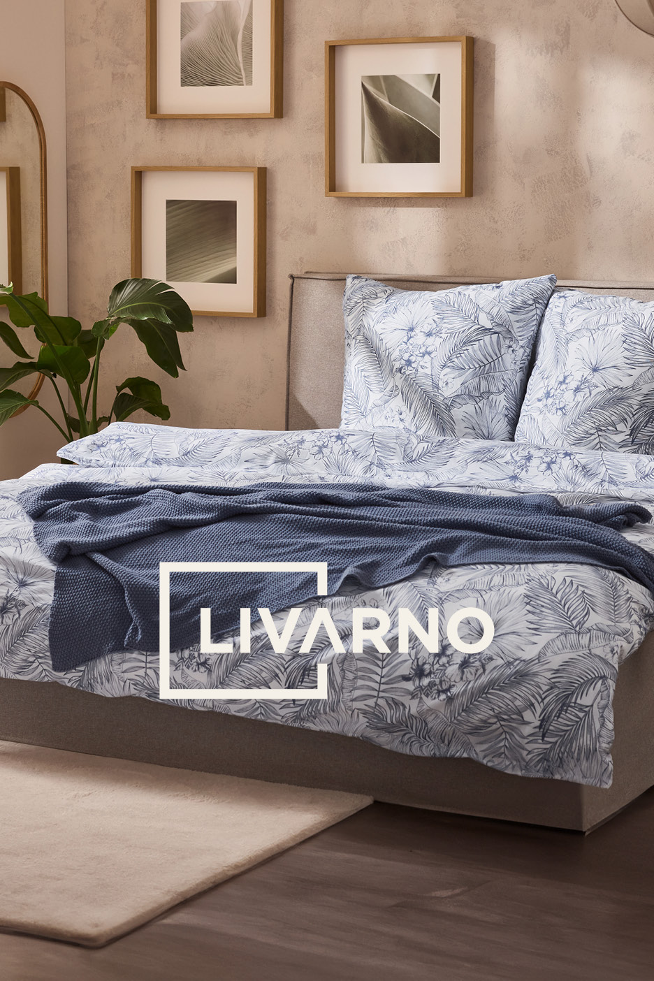 Camera da letto con letto matrimoniale, biancheria da letto a fantasia tropicale e coperta blu.