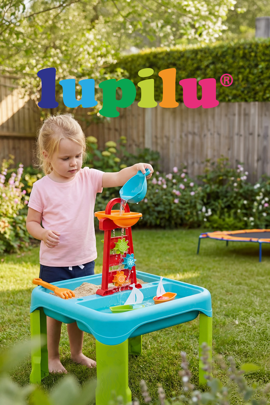 Bambina gioca con un tavolo da sabbia e acqua con mulino a vento in un giardino.