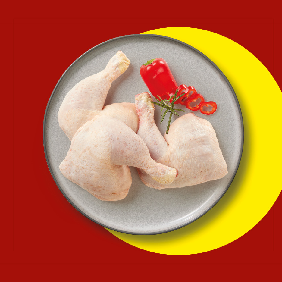 Cosce di pollo crude con peperoni rossi e rosmarino su un piatto grigio.