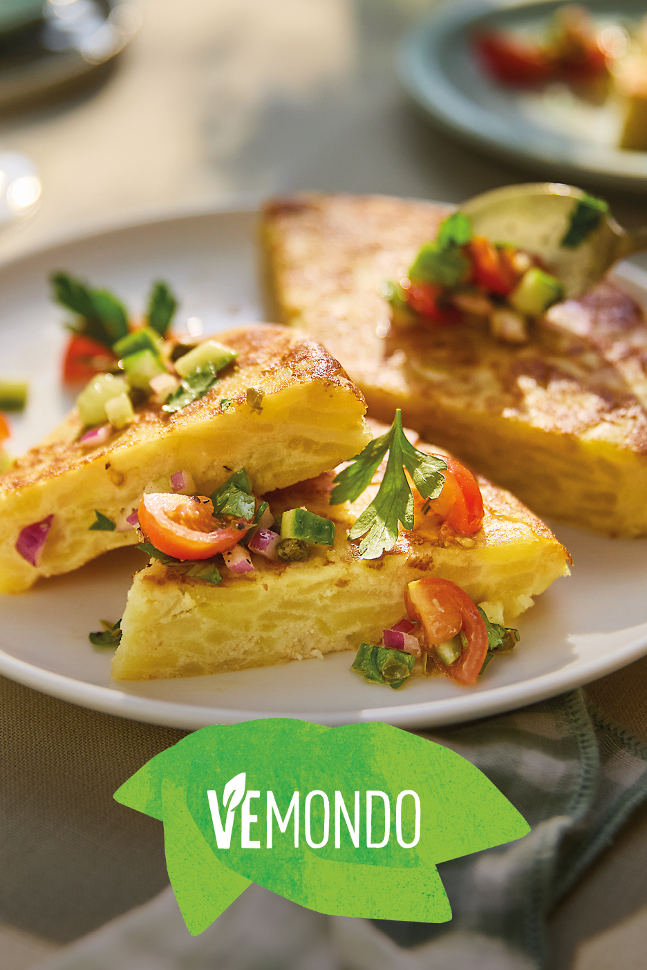 Frittata di patate con salsa fresca di pomodoro, cipolla e cetrioli, su un piatto bianco.