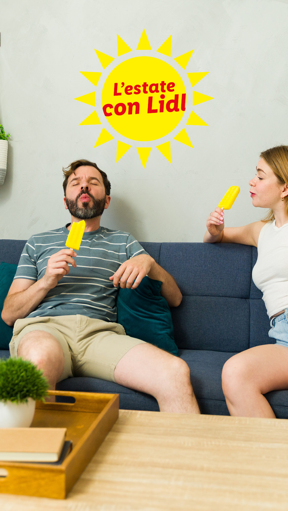 Coppia sul divano che mangia ghiaccioli, con un sole giallo e la scritta 'L'estate con Lidl'.