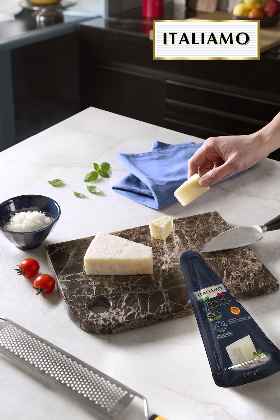 Formaggio Pecorino Romano su tagliere di marmo con grattugia, pomodorini e basilico.