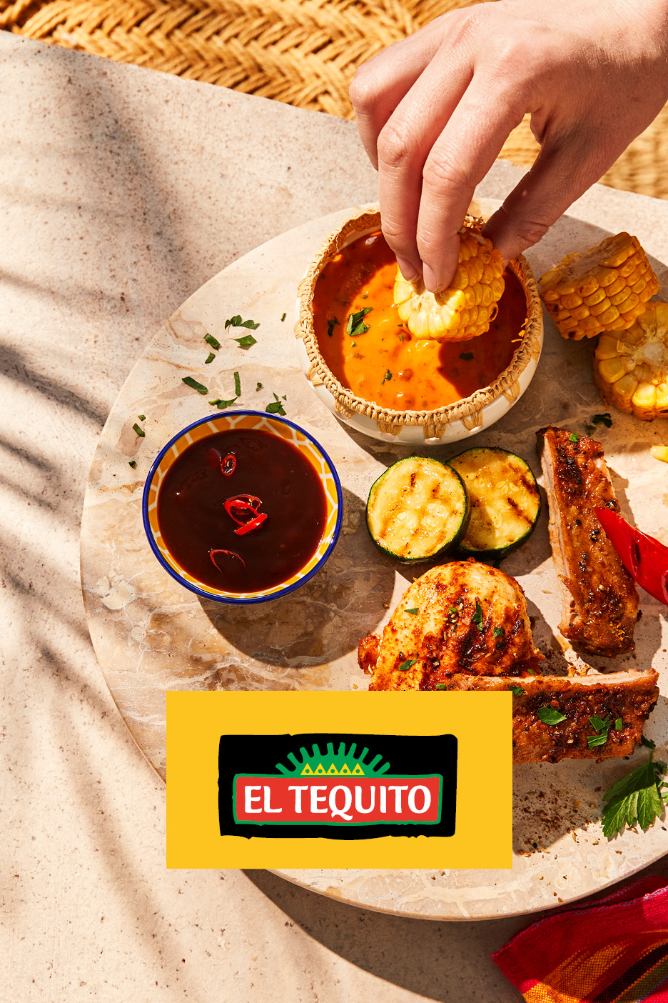 Piatto con pannocchie di mais, salse, zucchine grigliate e carne, con logo El Tequito.