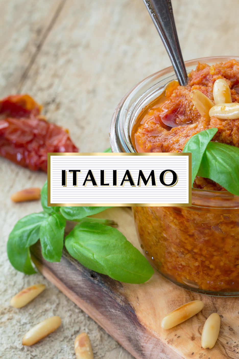 Pesto rosso in un barattolo di vetro con basilico, pinoli e pomodori secchi su legno.
