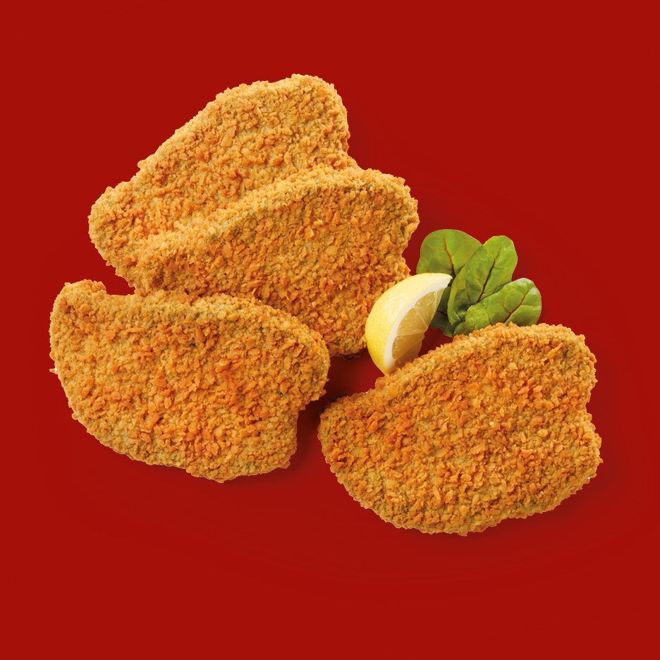 Cotolette impanate con limone e spinaci su sfondo rosso
