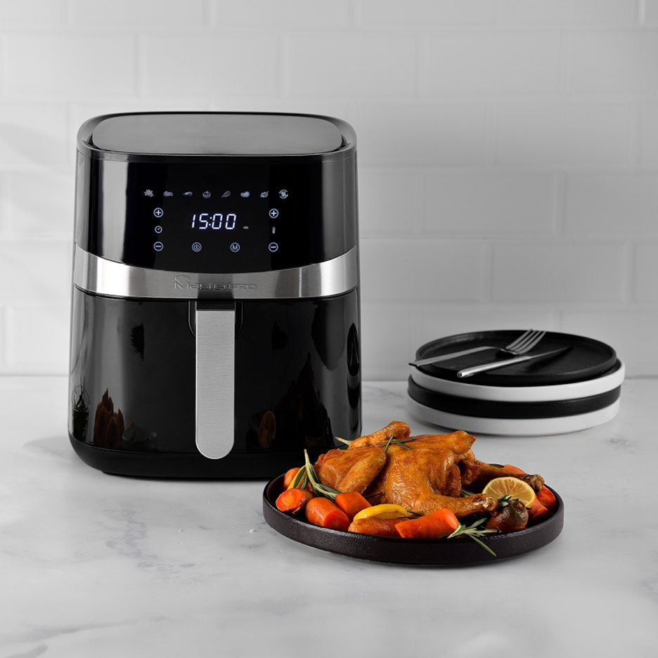 Friggitrice ad aria Masterpro nera con pollo arrosto e verdure su un piatto