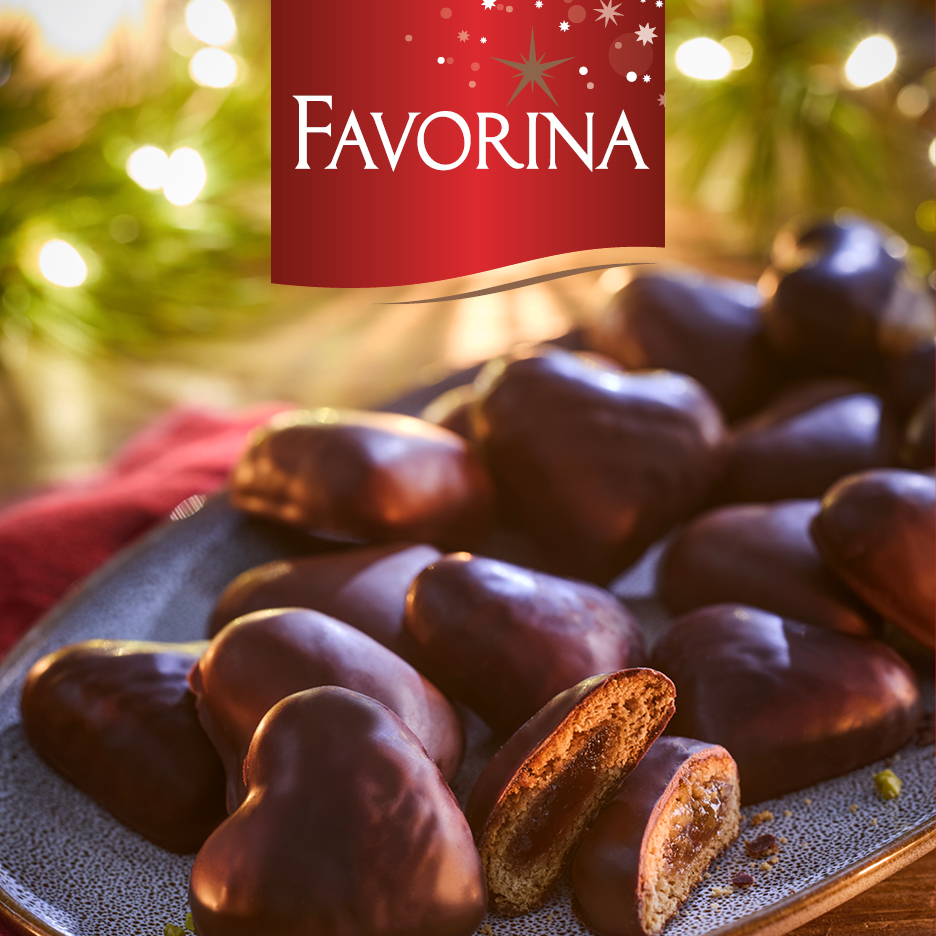 Biscotti di pan di zenzero a forma di cuore ricoperti di cioccolato Favorina su un piatto.