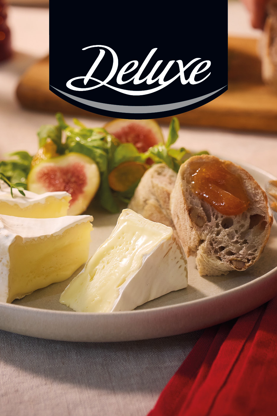 Deluxe formaggio a pasta molle servito su un piatto con fette di pane, marmellata e fichi.