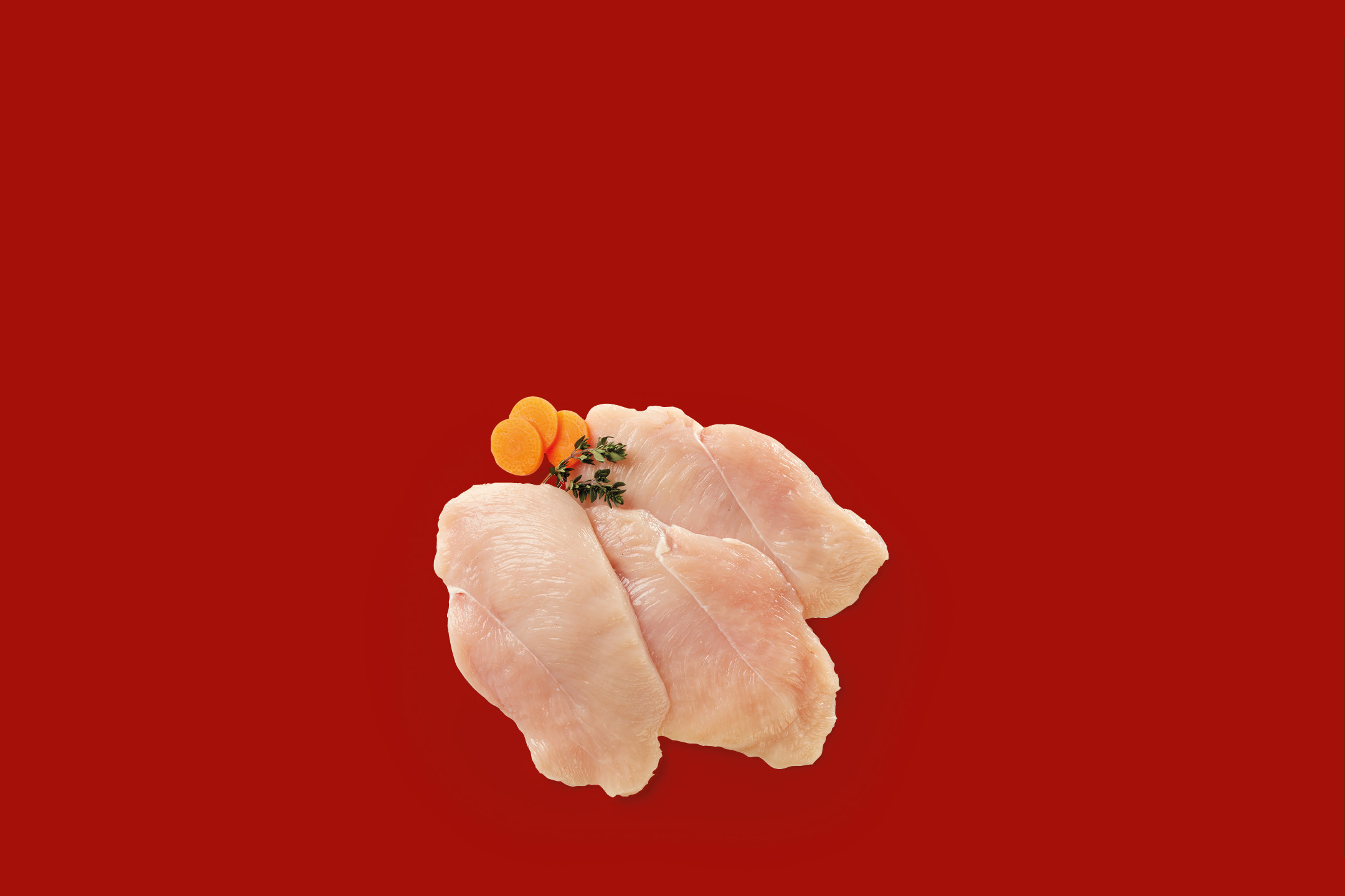 Fettine di petto di pollo crude con carote e timo su sfondo rosso.
