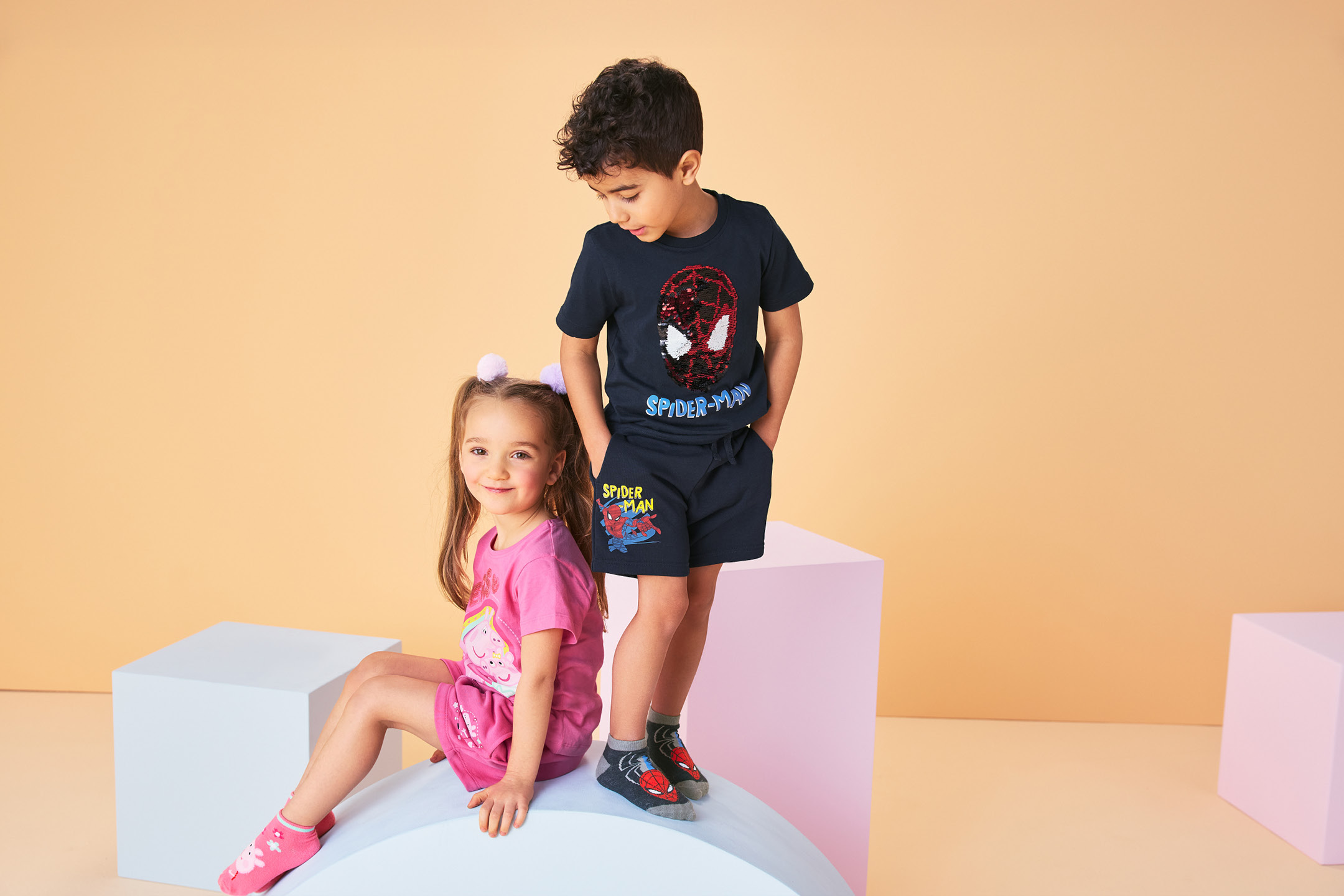 Bambini in magliette e pantaloncini con stampe di supereroi e cartoni animati.