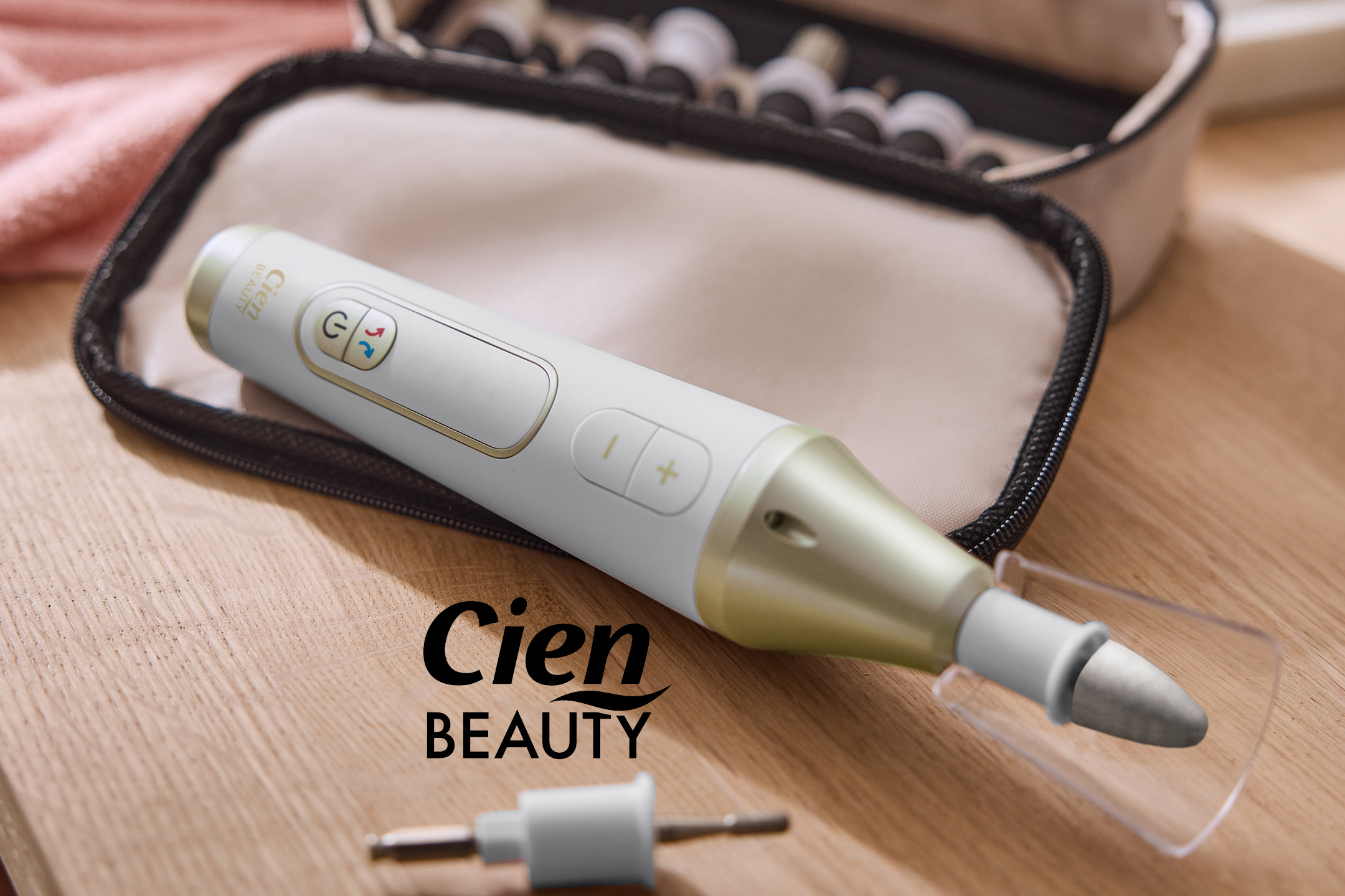 Dispositivo per manicure e pedicure con accessori su un tavolo di legno, con custodia aperta.